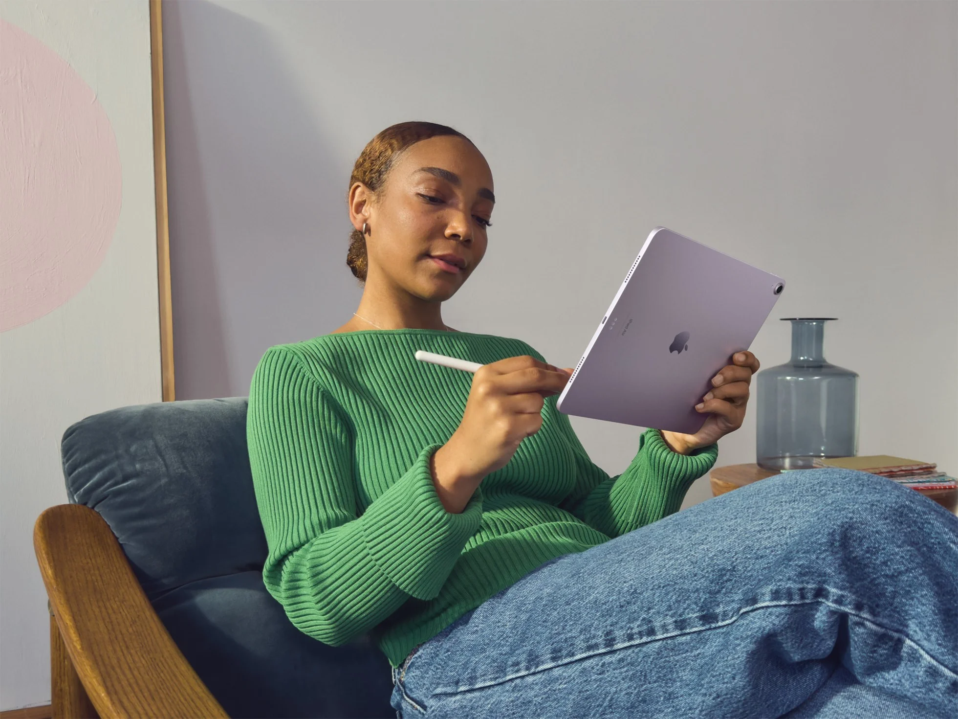 a woman sitting on a couch holding a tablet