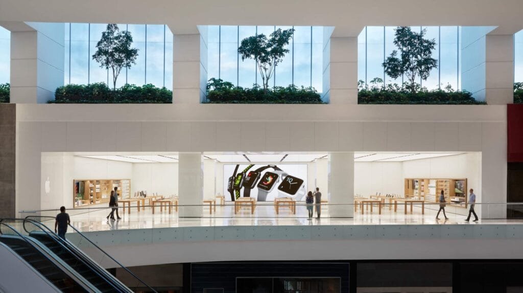 A modern Apple Store entrance with a large glass facade and a prominent Apple logo.